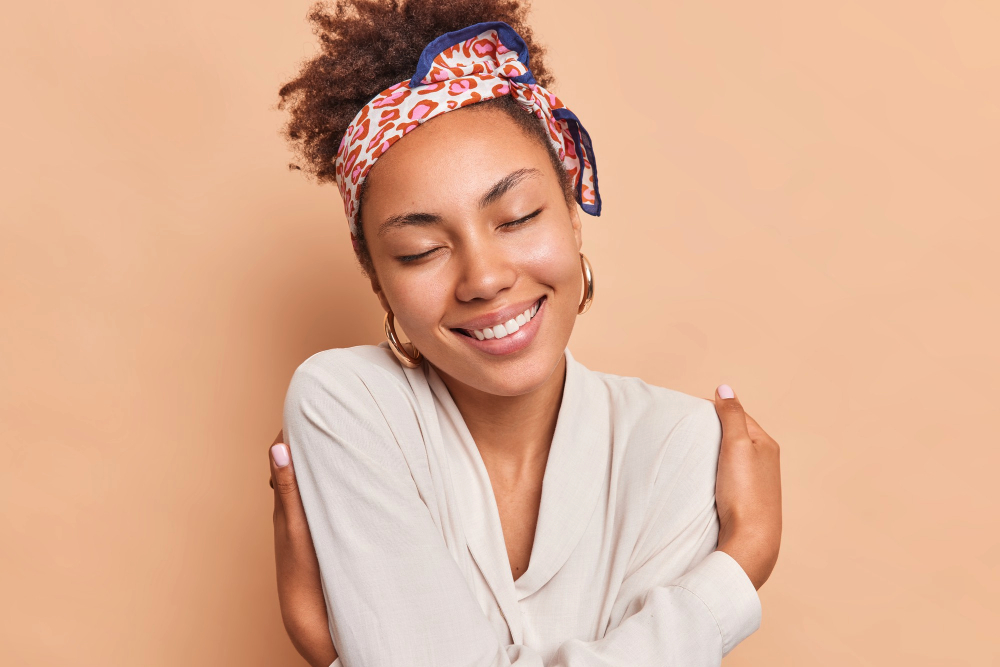 Black woman with glowing skin smiling after skincare routine